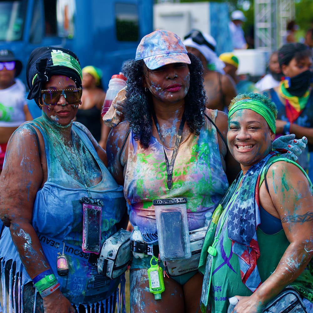 women at carnival covered in colorful paint